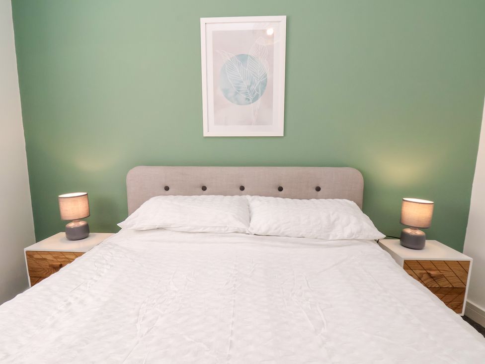 A bedroom with a bed and bedside tables at Apartment 1 ( 2 bed ) in Redcar