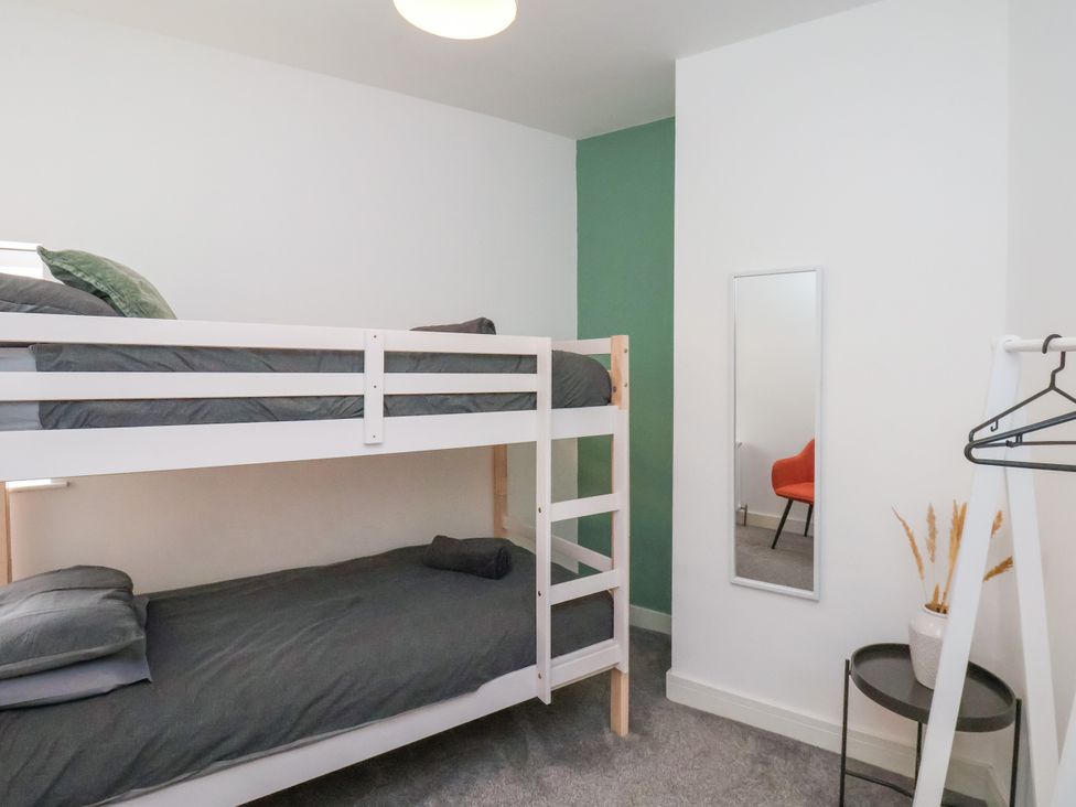 A bedroom with a bunk bed and mirror at Apartment 1 ( 2 bed ) in Redcar