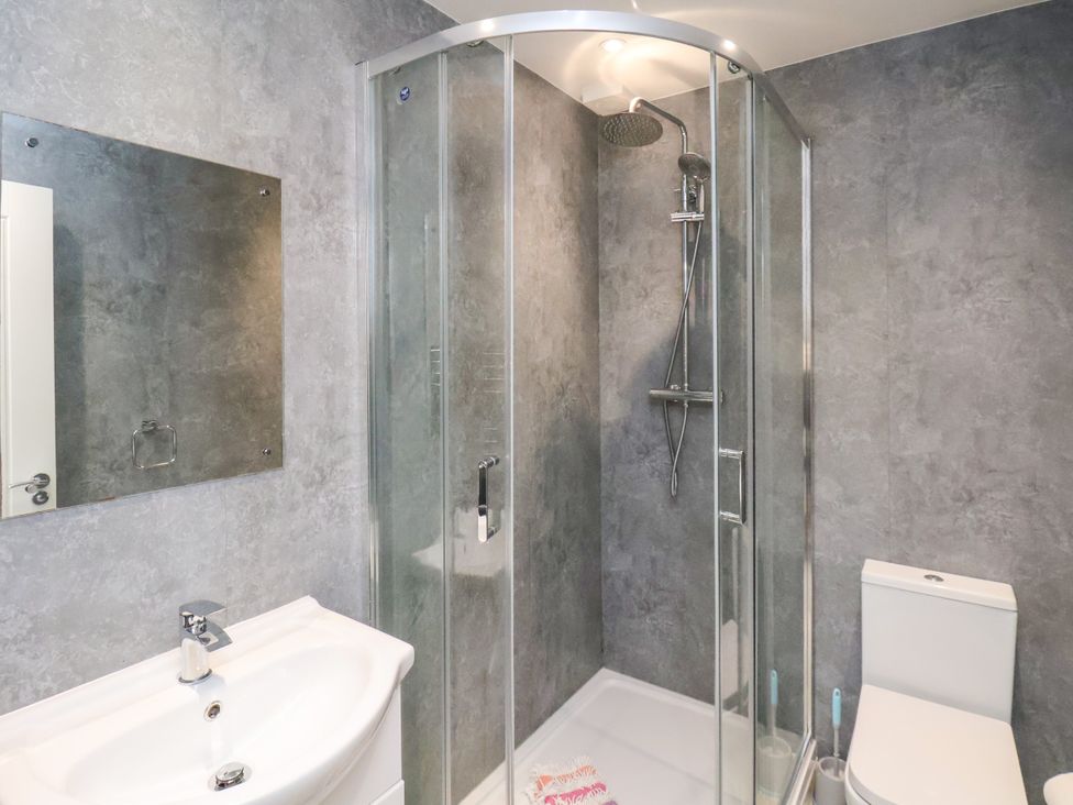 A bathroom with a shower, mirror, and wash basin at Apartment 1 ( 2 bed ) in Redcar