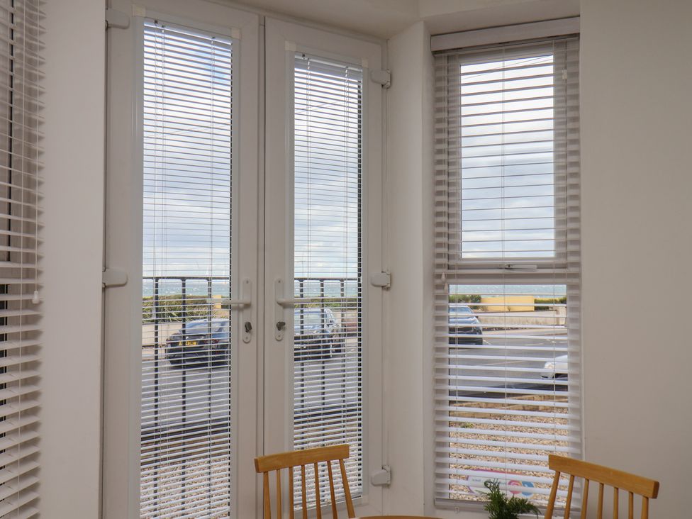 A dining room with windows and table at Glenholme Apartment 1 in Redcar