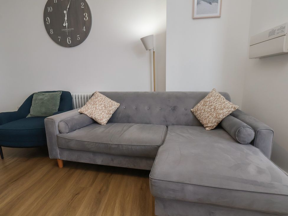 A living room with a sofa and an armchair at Glenholme Apartment 1 in Redcar
