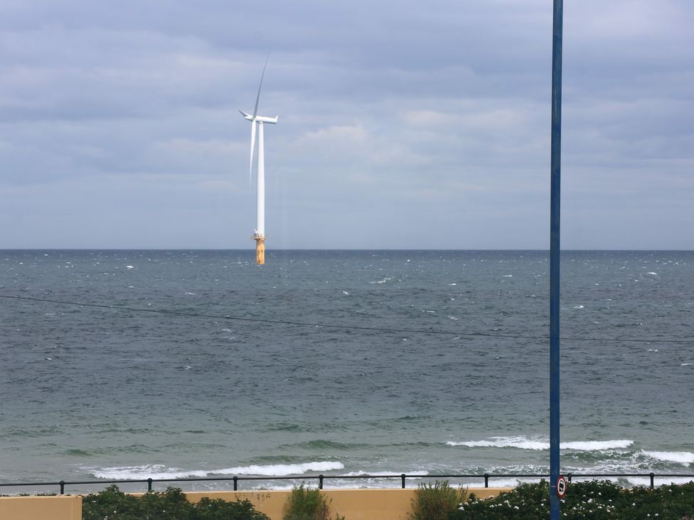 A wind turbine in the ocean with a cloudy sky at Glenholme Apartment 1 in Redcar