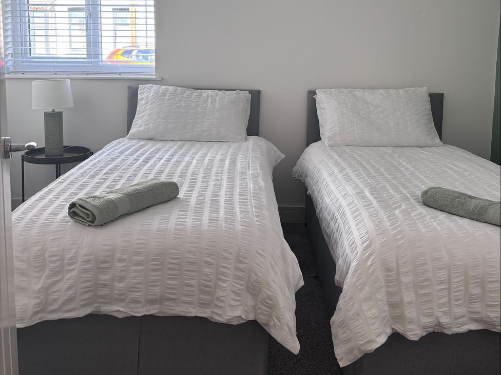 A bedroom with two single beds and a lamp at Glenholme Apartment 1 Redcar