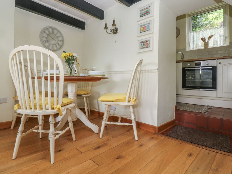 A dining room with a table and chairs at Driftwood Cottage in St. Austell