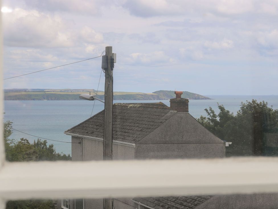 A view of the ocean and hills from a window at Driftwood Cottage in St. Austell