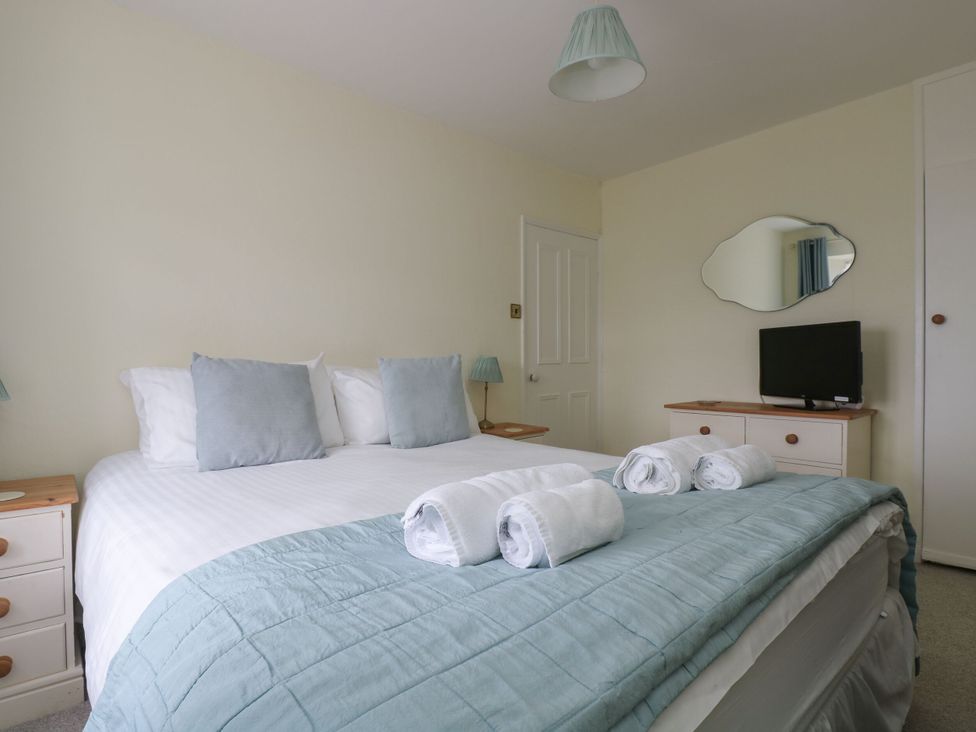A bedroom with a bed and television at Driftwood Cottage in St. Austell