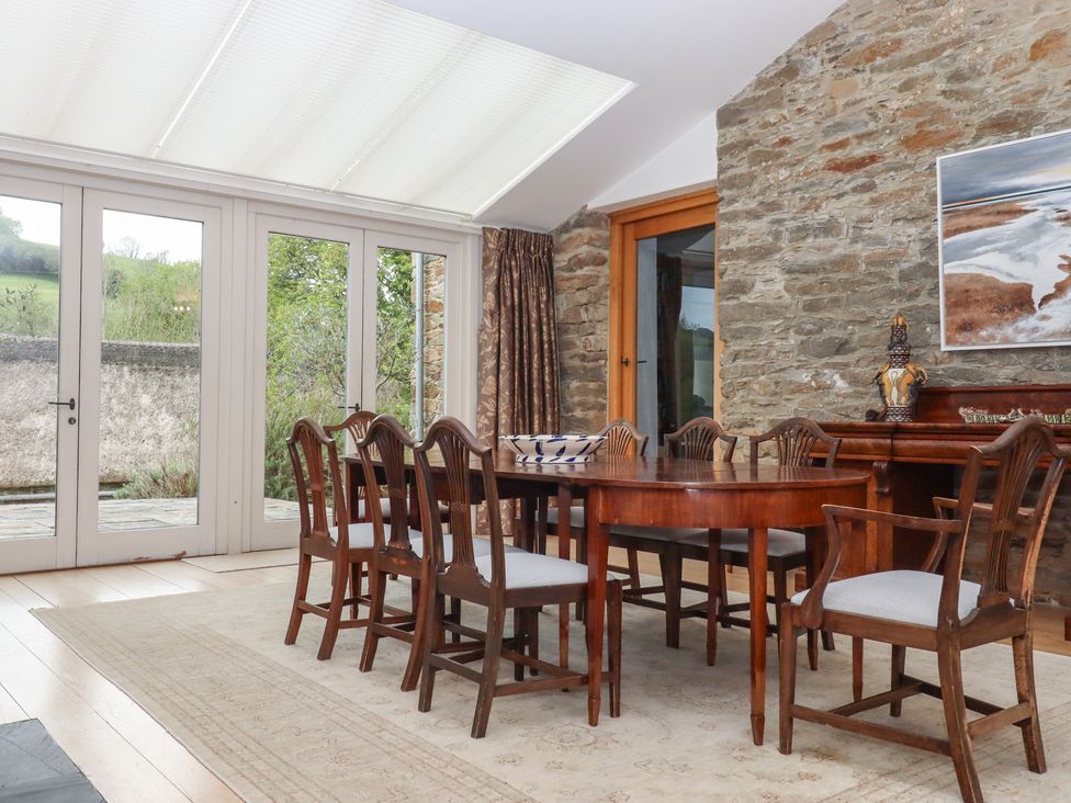 A dining room with a table and chairs at Lower Velwell Barn in Totnes
