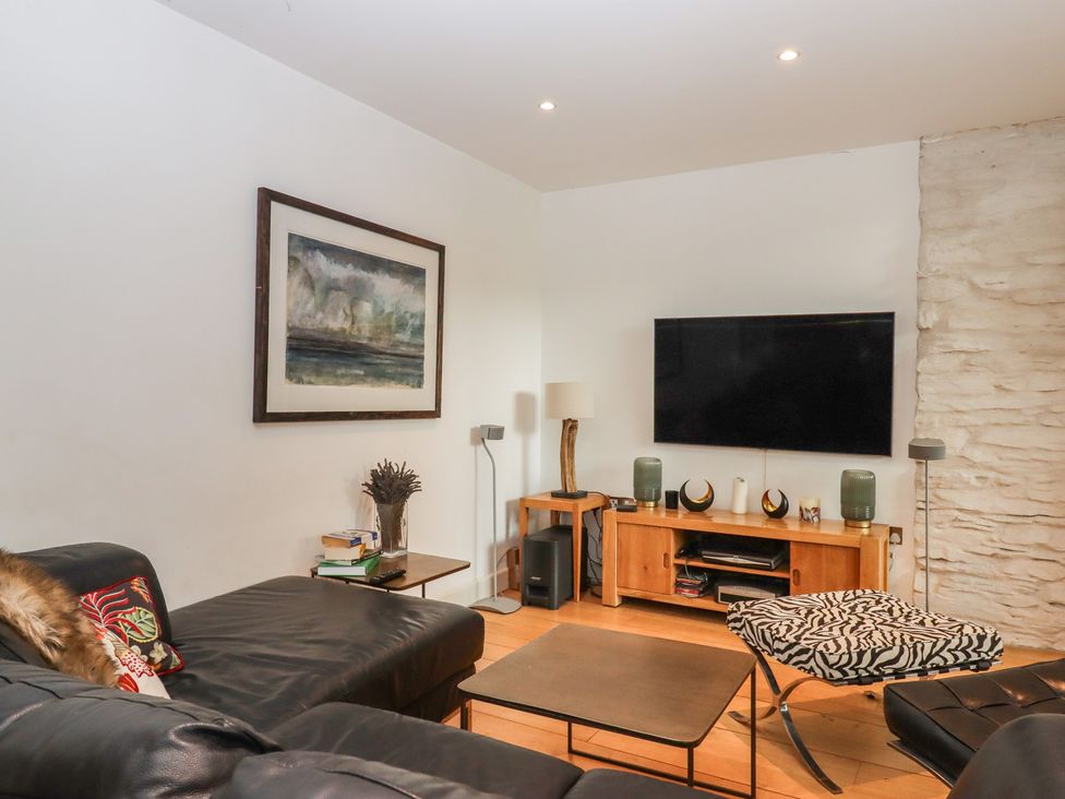 A living room with a sofa and television at Lower Velwell Barn in Totnes