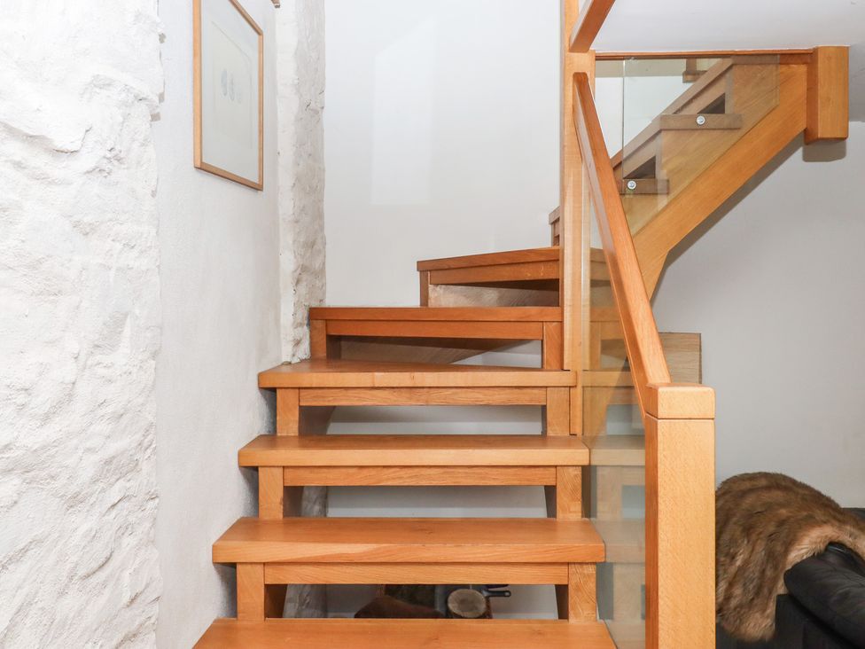 Stairs with wooden steps and railing at Lower Velwell Barn in Totnes
