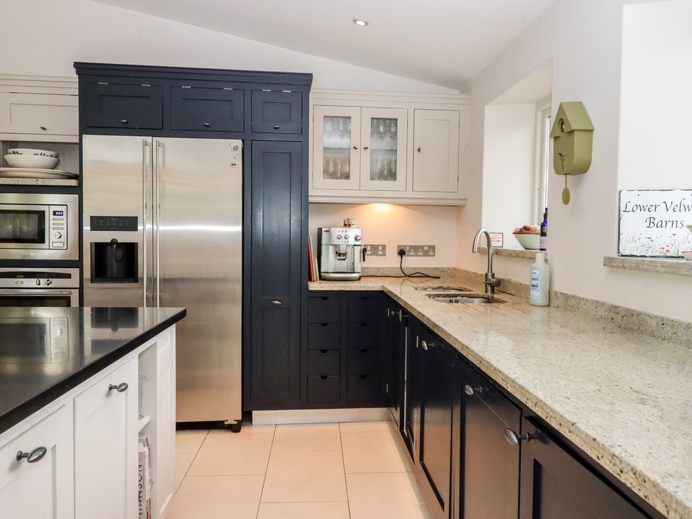 A kitchen with appliances and cabinets at Lower Velwell Barn in Totnes