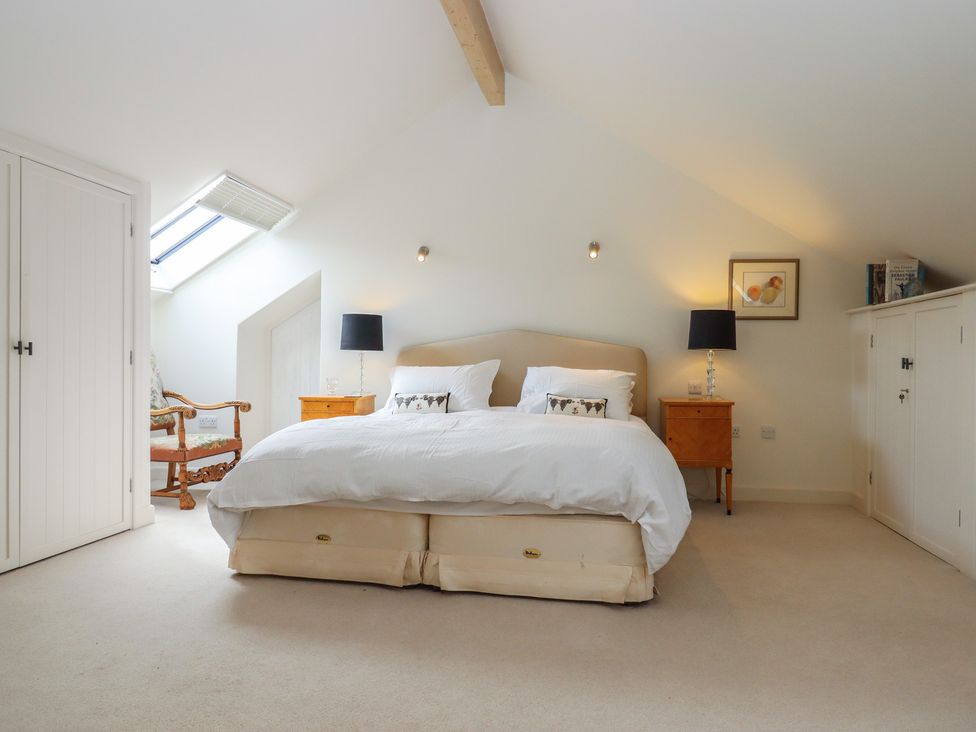 A bedroom with a bed and bedside tables at Lower Velwell Barn in Totnes