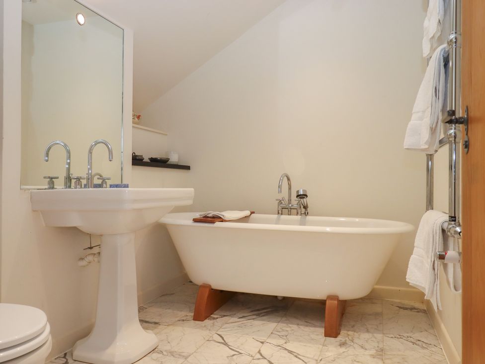 A bathroom with a bathtub and sink at Lower Velwell Barn in Totnes