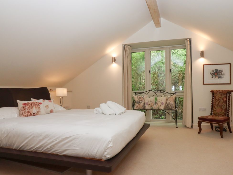 A bedroom with a bed and window at Lower Velwell Barn in Totnes
