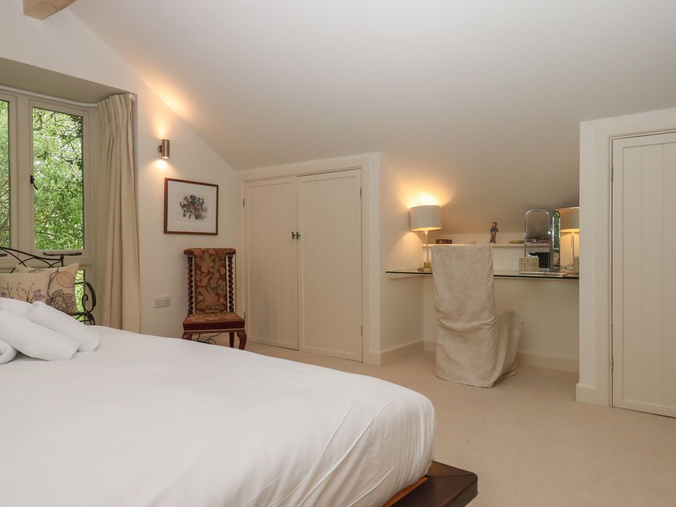 A bedroom with a bed and desk at Lower Velwell Barn in Totnes
