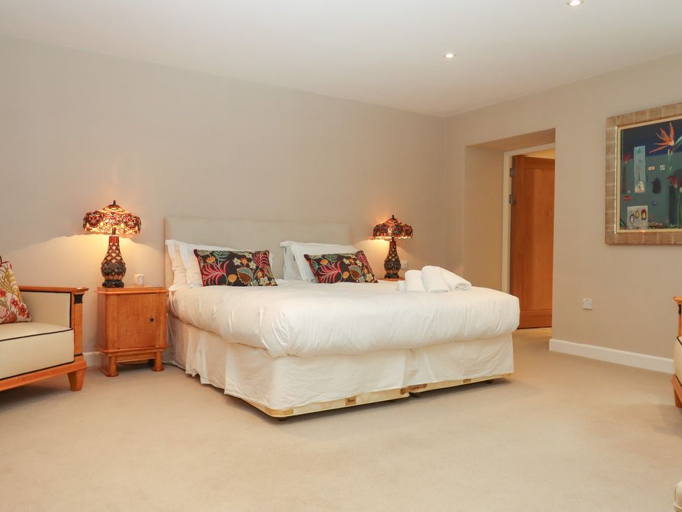 A bedroom with a bed and lamps at Lower Velwell Barn in Totnes