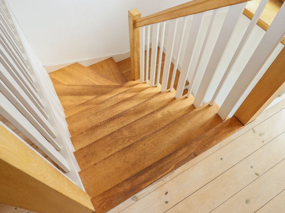 A staircase with wooden steps and a handrail at Lower Velwell Barn in Totnes