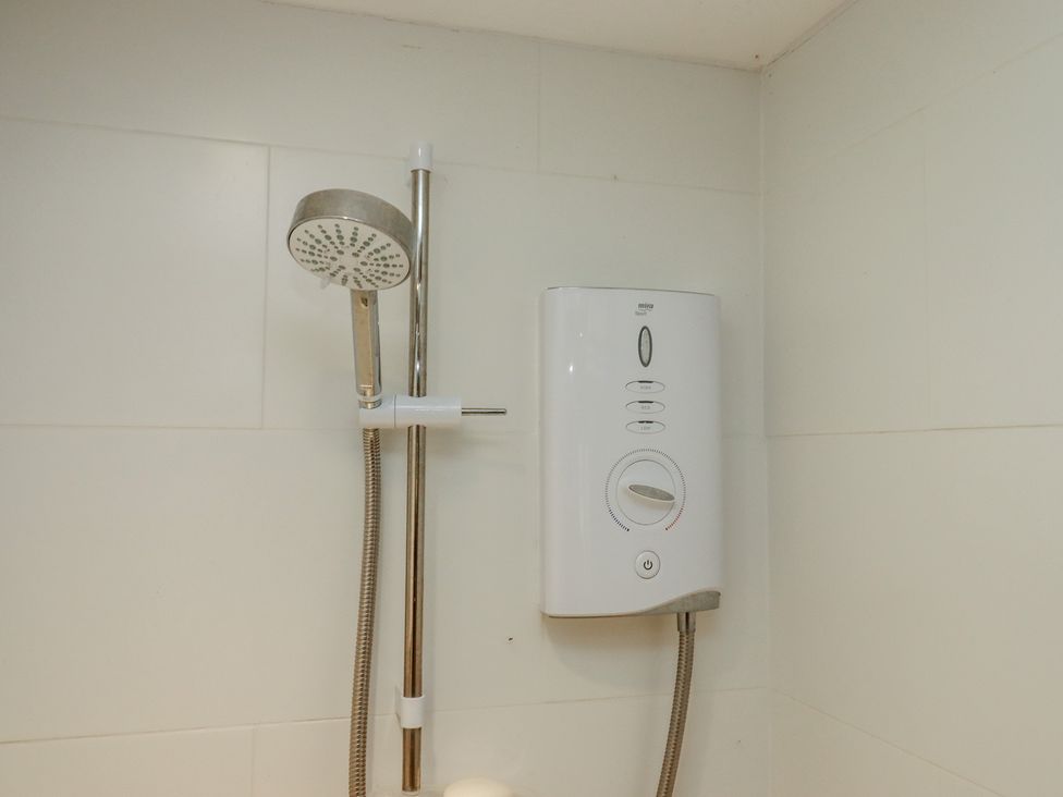 A shower with a showerhead and control unit at Lower Velwell Barn in Totnes