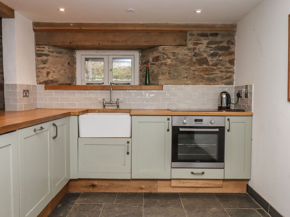 A kitchen with a sink, oven, and kettle at Lower Velwell Barn in Totnes