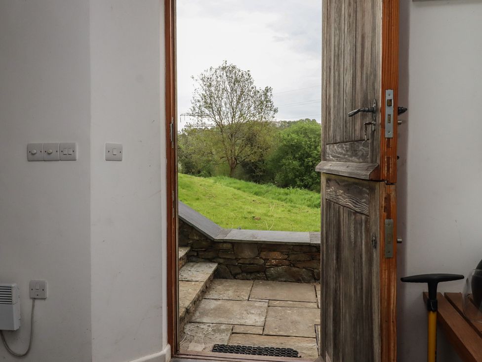 An entryway with a door open to a grassy area at Lower Velwell Barn in Totnes