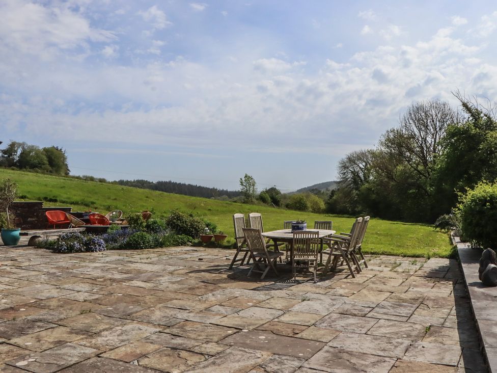 A garden with a dining table and chairs at Lower Velwell Barn in Totnes
