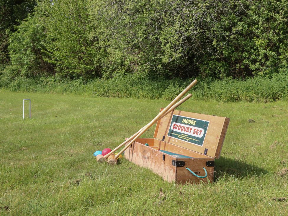 A croquet set with mallets and balls on grass at Lower Velwell Barn Totnes