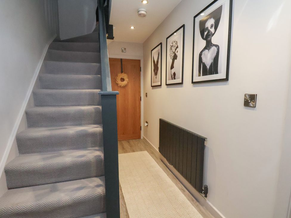 A hallway with stairs and artwork on the wall at Pearl Stone House in Whitby
