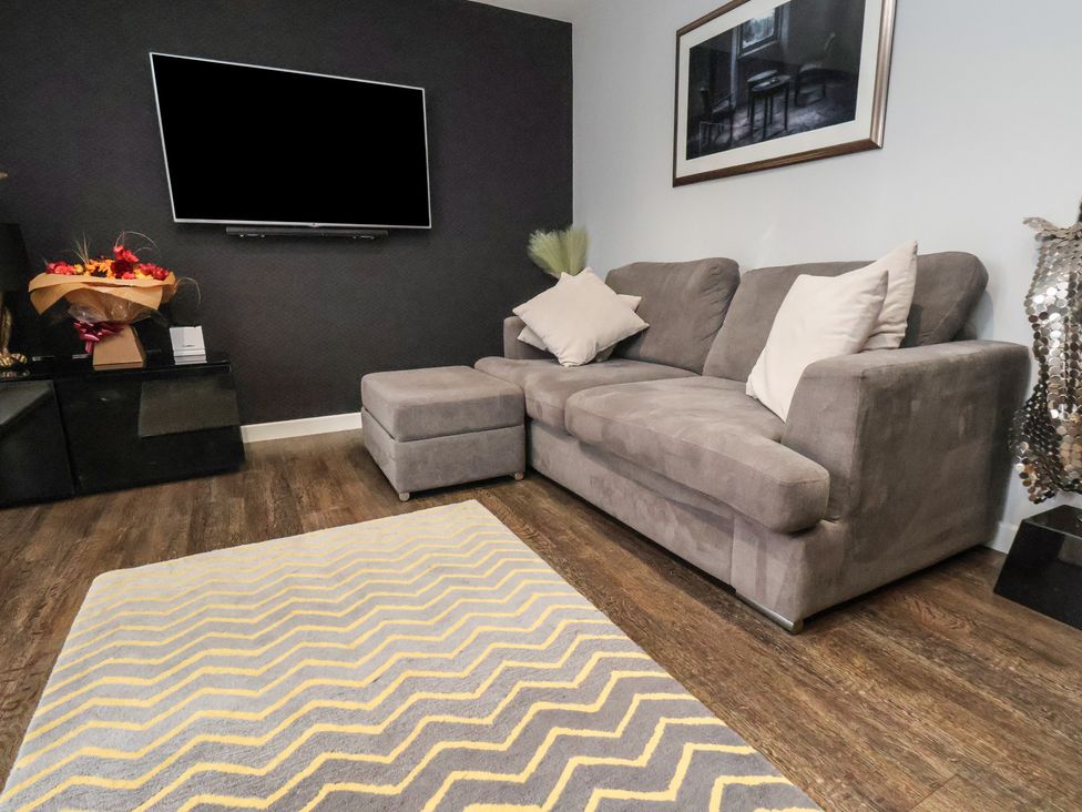 A living room with a couch and television at Pearl Stone House in Whitby