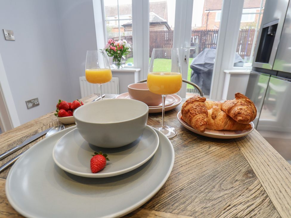 A dining room table set with bowls, plates, croissants and juice at Pearl Stone House in Whitby