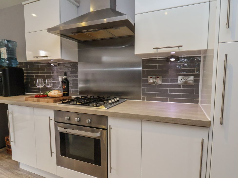 A kitchen with a gas stove and countertop at Pearl Stone House in Whitby