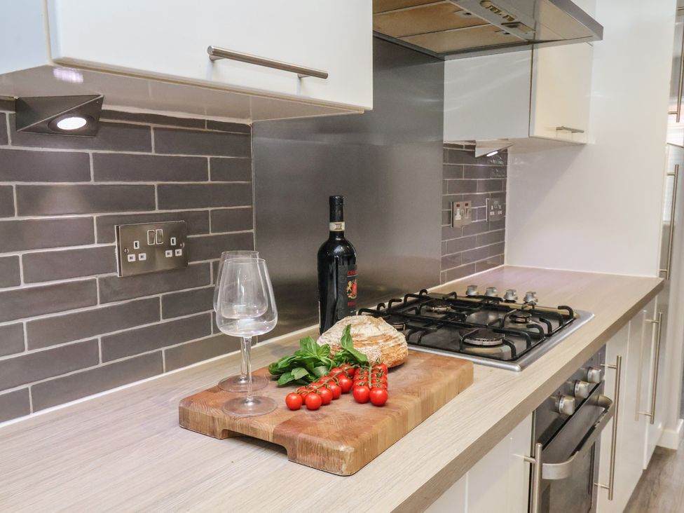 A kitchen with a cutting board and wine bottle at Pearl Stone House in Whitby