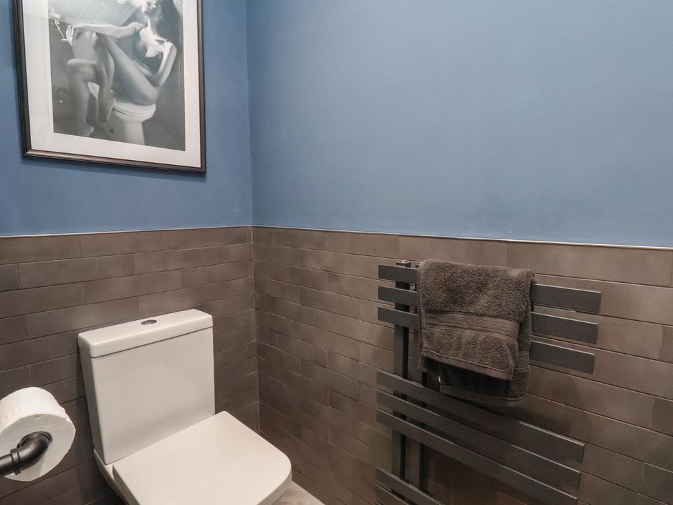 A bathroom with a toilet and towel rack at Pearl Stone House in Whitby