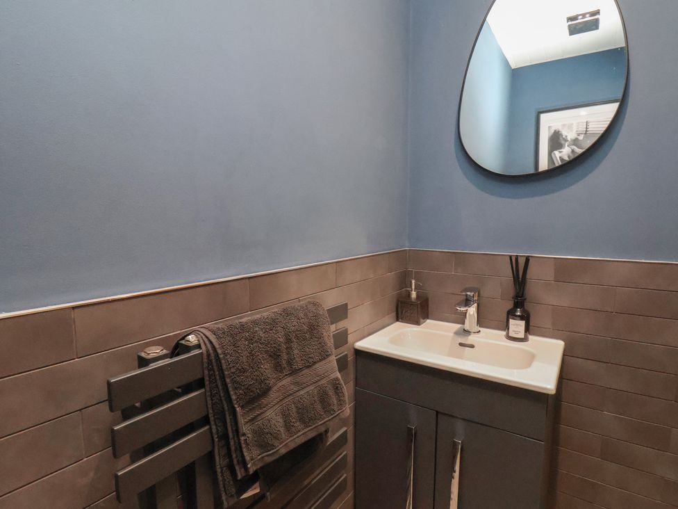 A bathroom with a sink and towel on a rail at Pearl Stone House in Whitby