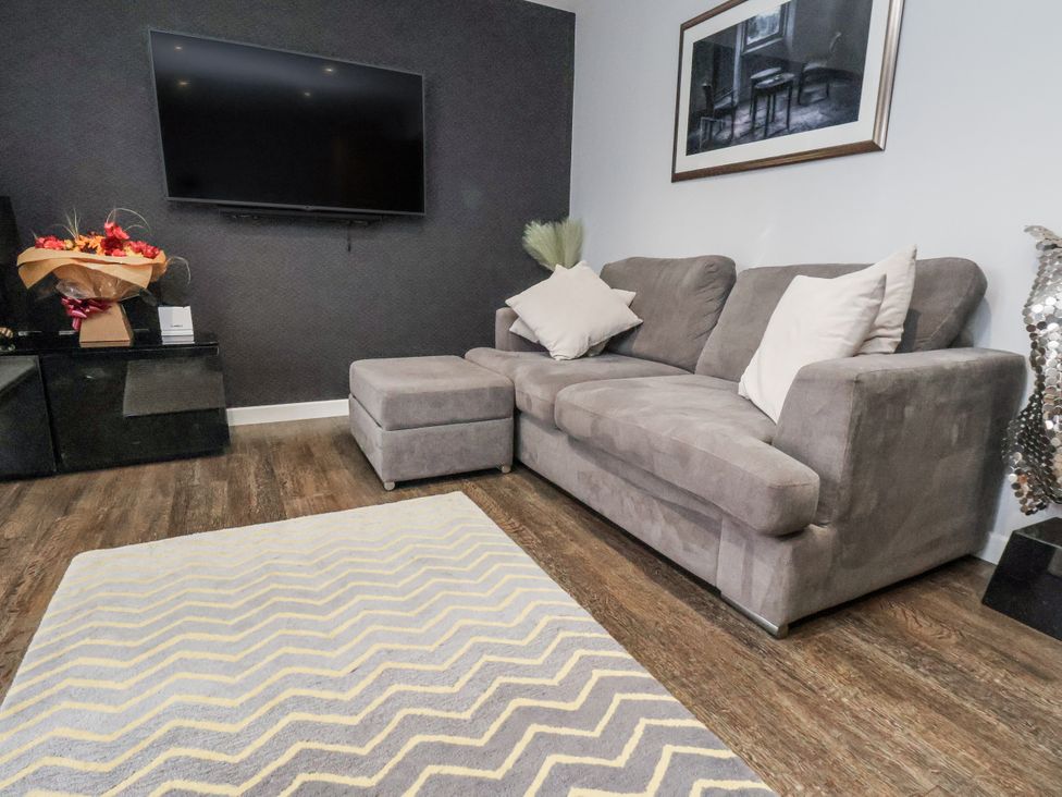 A living room with a sofa and television at Pearl Stone House in Whitby