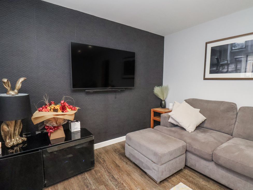 A living room with a television and sofa at Pearl Stone House in Whitby