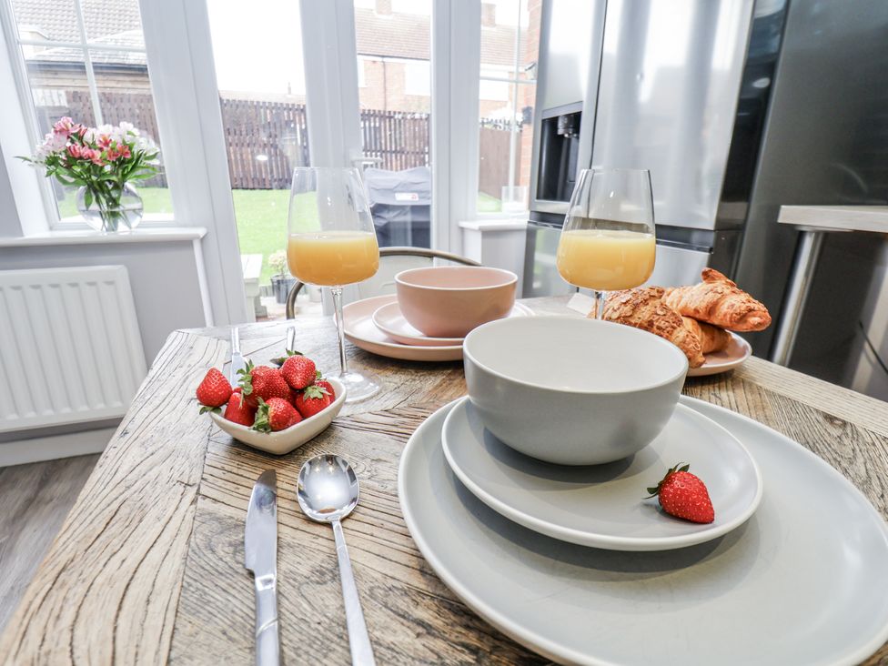 A dining table with plates and food at Pearl Stone House in Whitby