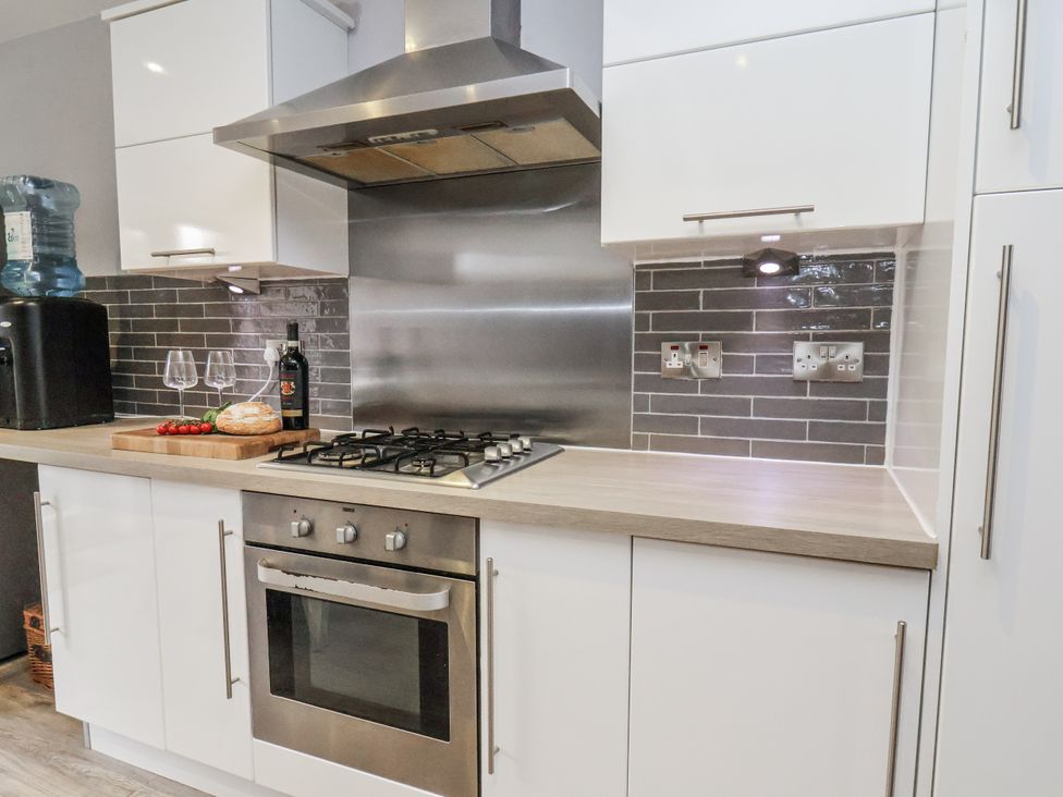 A kitchen with stove, oven, and water cooler at Pearl Stone House in Whitby