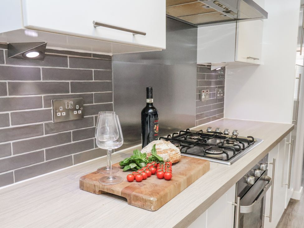 A kitchen with a cutting board and wine bottle at Pearl Stone House in Whitby