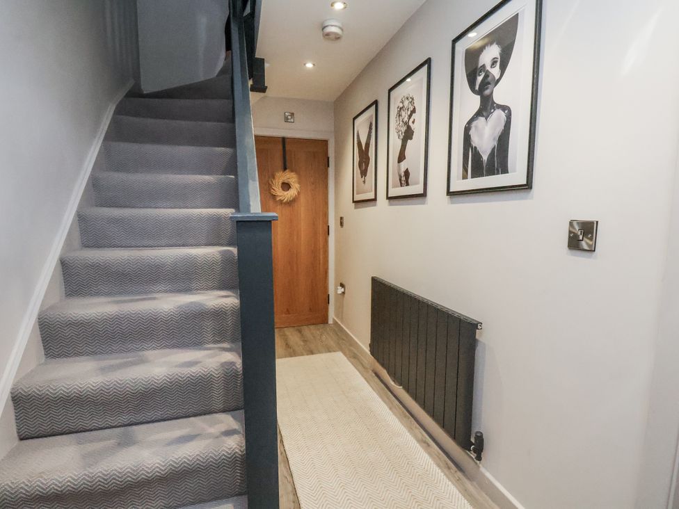 A hallway with a staircase and wall art at Pearl Stone House in Whitby