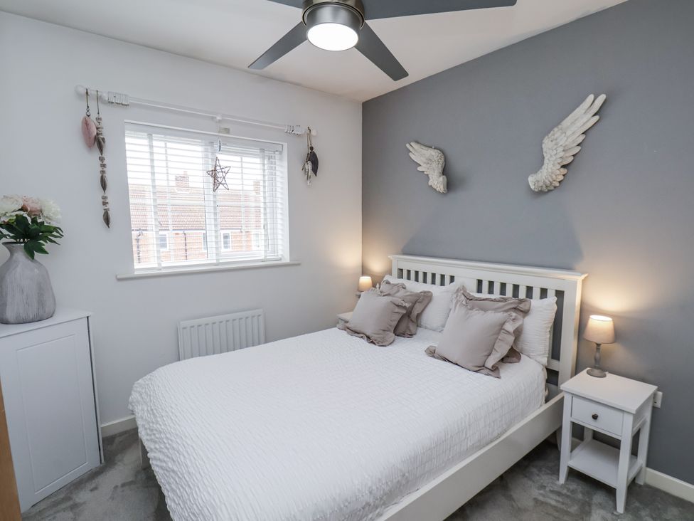 A bedroom with a bed and decorative wall art at Pearl Stone House Whitby