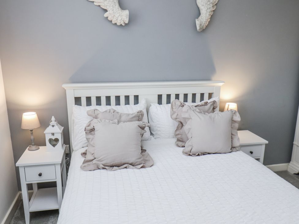 A bedroom with a bed and bedside tables at Pearl Stone House in Whitby