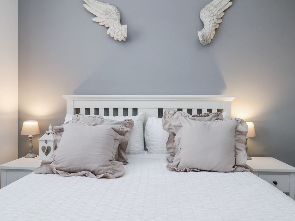 A bed with pillows and bedside lamps at Pearl Stone House in Whitby