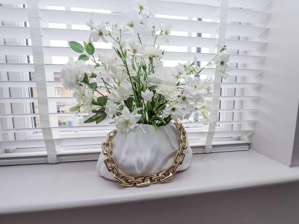 A vase with flowers on a windowsill at Pearl Stone House in Whitby