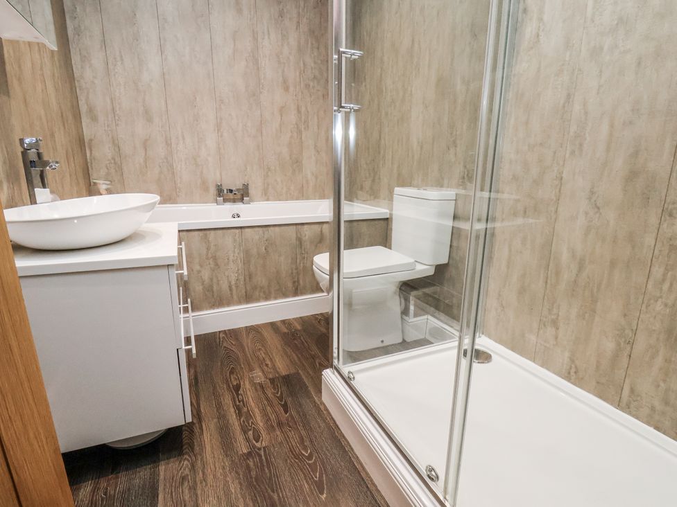 A bathroom with a sink, shower, and toilet at Pearl Stone House in Whitby