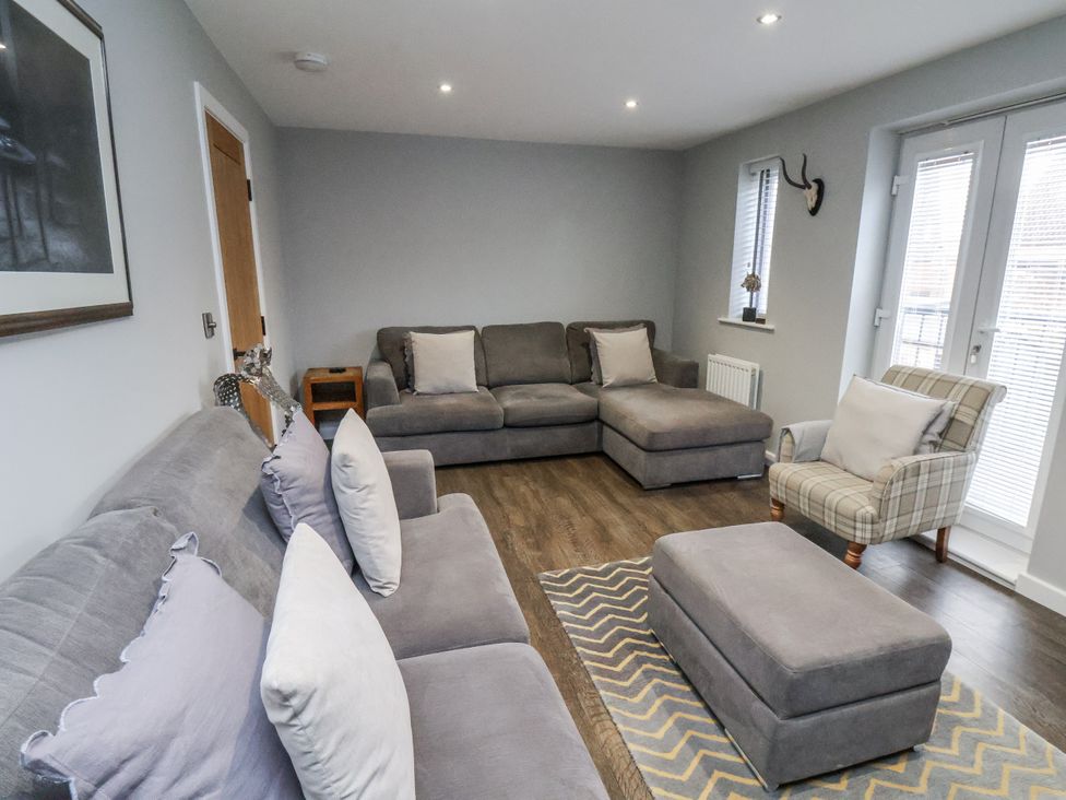 A living room with a couch and ottoman at Pearl Stone House in Whitby