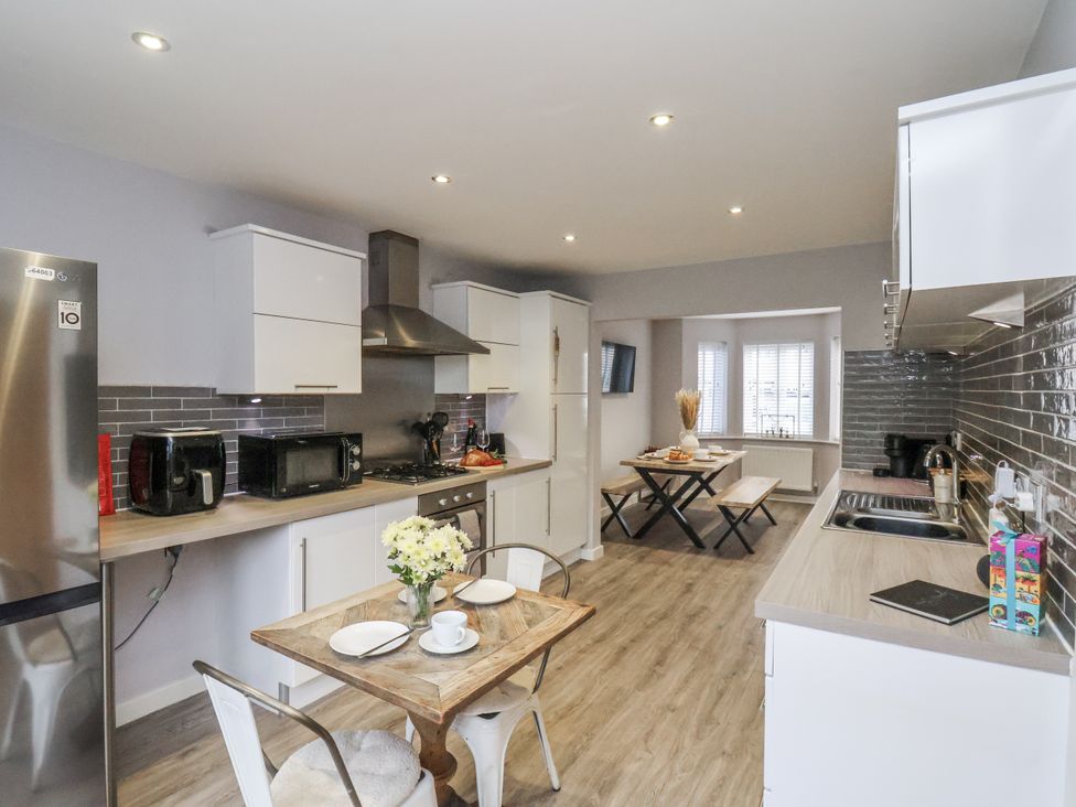 A kitchen with a table and chairs at Pearl Stone House in Whitby