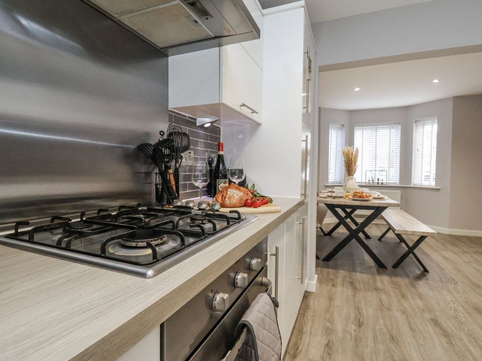 A kitchen with a gas stove and dining area at Pearl Stone House in Whitby