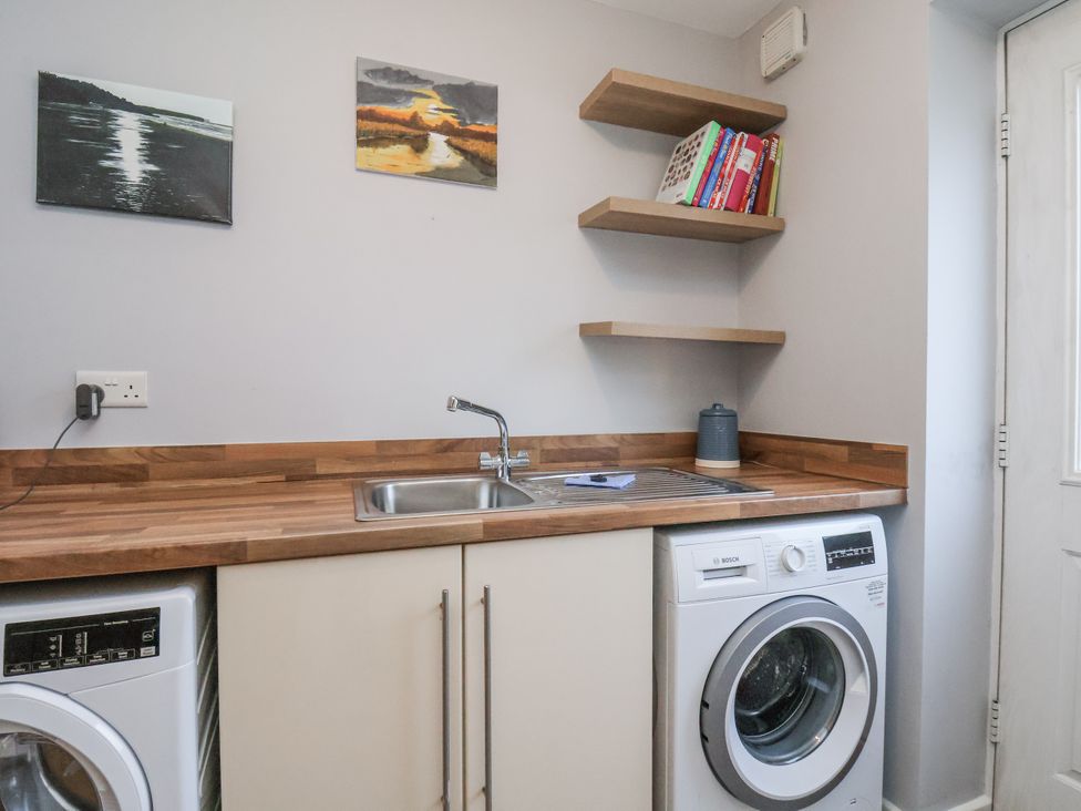 A laundry room with a washing machine and sink at Pearl Stone House in Whitby
