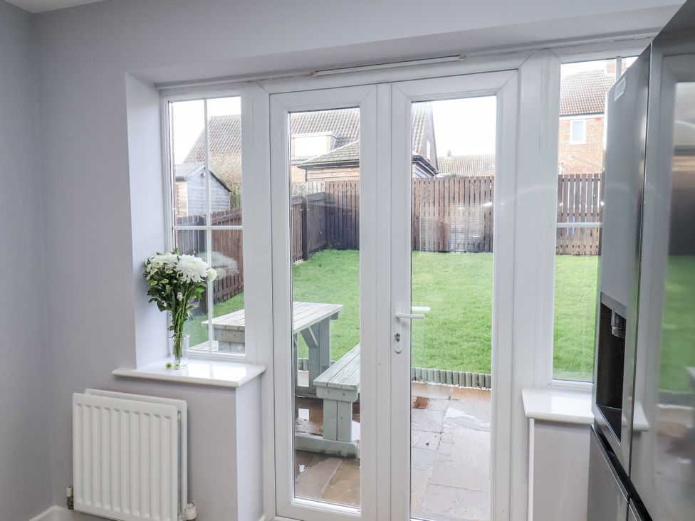 A kitchen with a sliding door leading to a garden at Pearl Stone House in Whitby
