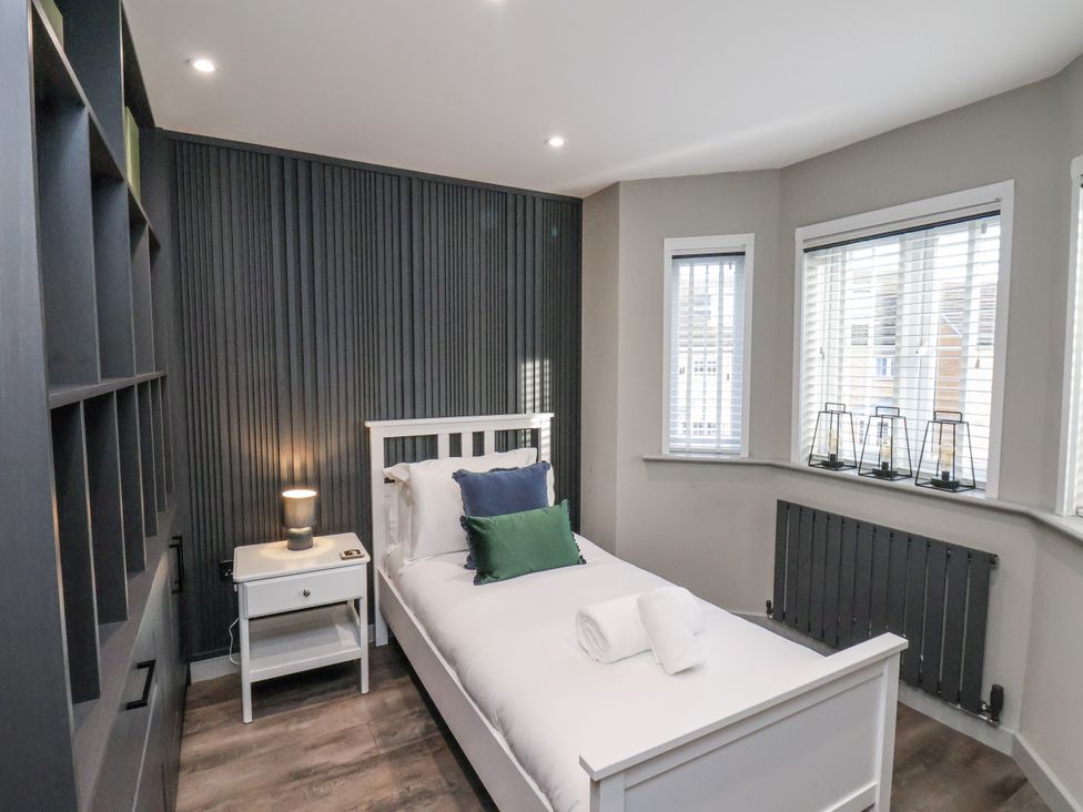 A bedroom with a single bed and nightstand at Pearl Stone House in Whitby