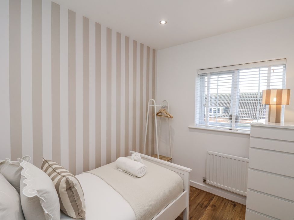 A bedroom with a bed and a window at Pearl Stone House Whitby